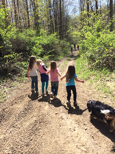 Kids hold hands as they hike along trails at the cabin rental.